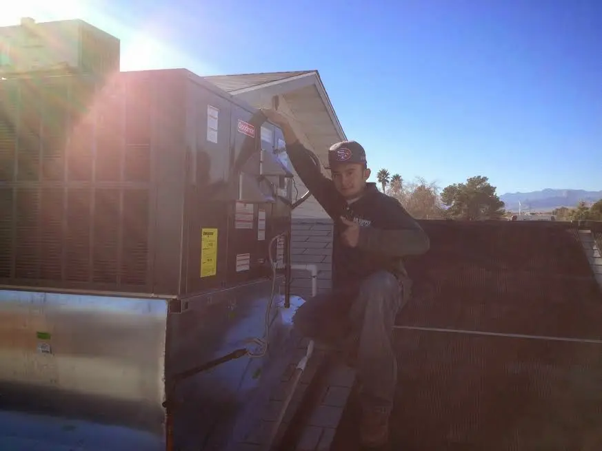 HVAC technician performing Heat Pump Repair on a rooftop unit in Parkersburg
